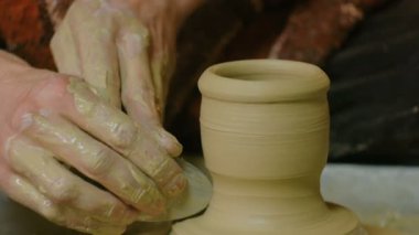 Çömlek atölyesinde özel bir aletle profesyonel çömlekçi şekillendirme kupası