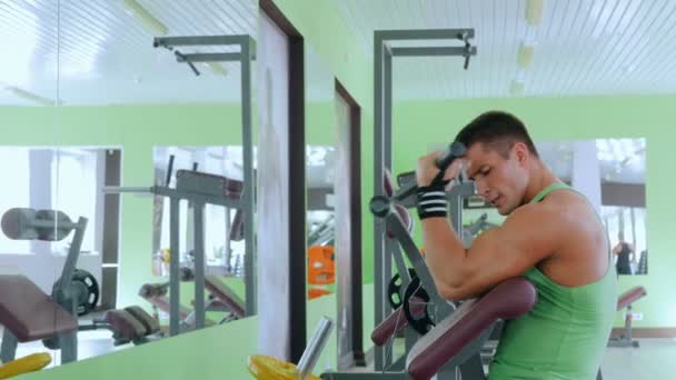 Jeune homme athlétique travaillant sur l'équipement d'exercice de fitness à la salle de gym — Video