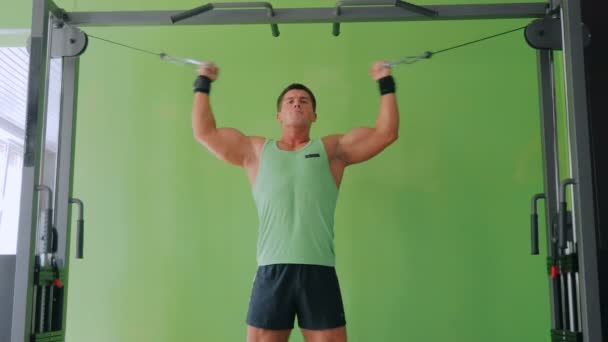 Atletisk ung man tränar på fitness träningsutrustning på gym — Stockvideo