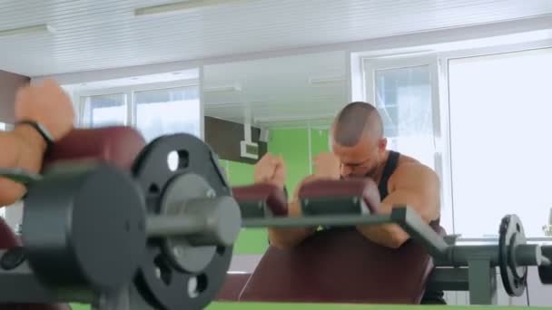 Sportieve jongeman uit te werken aan fitness-apparatuur van de oefening op sportschool — Stockvideo