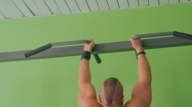 Barfiks çekmek vasıl jimnastik salonu yapıyor atletik genç adam