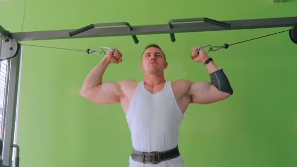 Athletischer junger Mann beim Training an Fitnessgeräten im Fitnessstudio — Stockvideo
