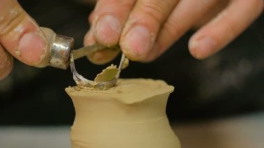 Çömlek atölyesinde özel aletli profesyonel çömlekçi oyma kupası