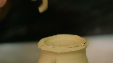 Çömlek atölyesinde özel aletli profesyonel çömlekçi oyma kupası