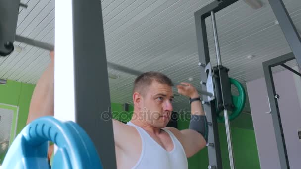 Jeune homme athlétique faisant des exercices avec haltère à la salle de gym, club de fitness — Video