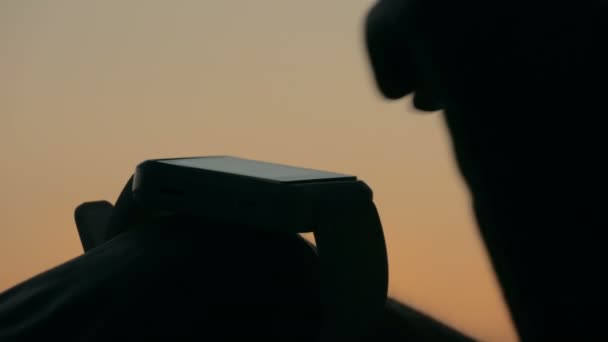 Mulher usando relógio inteligente na floresta após o pôr do sol — Vídeo de Stock