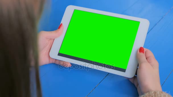 Женщина смотрит на планшетный компьютер с зеленым экраном — стоковое видео