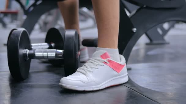 Primer plano de tiro de atlética mujer joven levantando pesas en el gimnasio — Vídeos de Stock