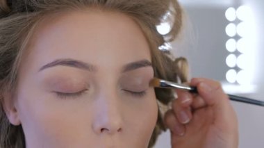 Profesyonel makyöz göz farı kullanıyor.