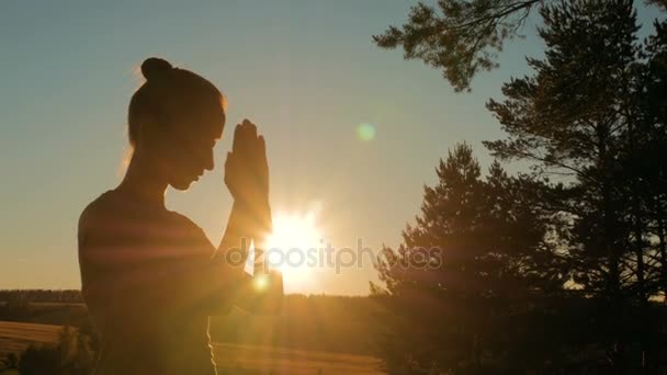 Sportieve vrouw bidden in park bij zonsondergang — Stockvideo