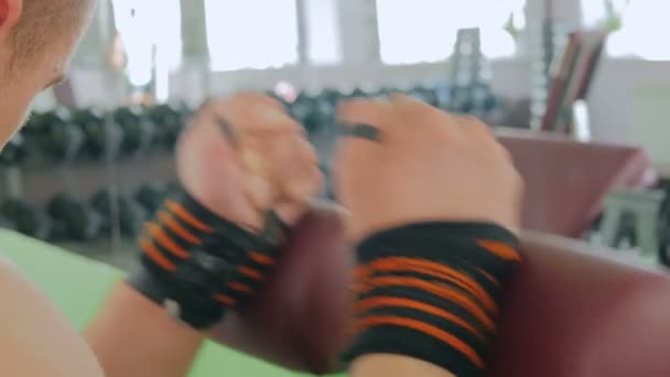 Lekkoatletycznego młody człowiek pracy na sprzęt do ćwiczeń fitness w siłowni — Wideo stockowe