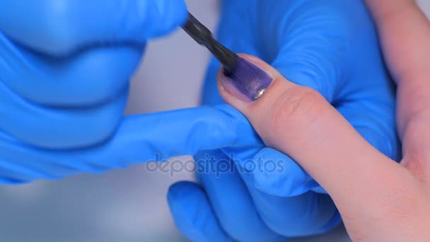 Esteticista profissional aplicando esmalte nas unhas femininas — Vídeo de Stock
