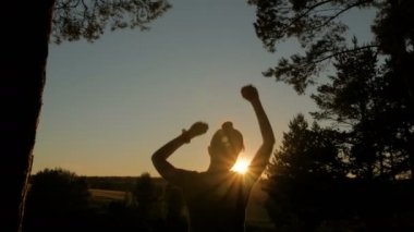 Dans ve having fun parkta günbatımında genç mutlu kadın