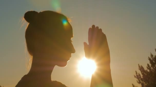 Sporty woman praying in park at sunset — Stock Video