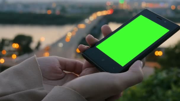 Vrouw op zoek naar smartphone met groen scherm — Stockvideo