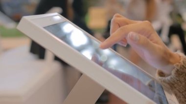 Şehir sergisinde etkileşimli dokunmatik ekran kullanan kadın