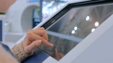 Şehir gösterisinde etkileşimli dokunmatik ekran kullanan kadın