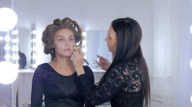 Sıvı ton temel uygulama kadının yüzünde makyaj sanatçısı