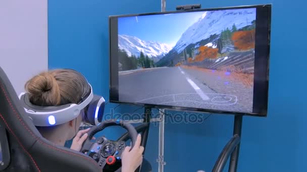 Young woman using virtual reality headset and playing in car drive simulator — Stock Video
