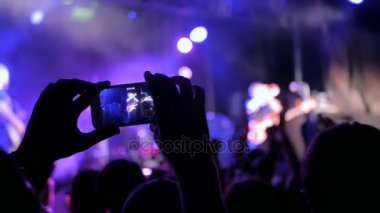 Akıllı telefonlu canlı müzik konserinin görüntülerini kaydeden eller.