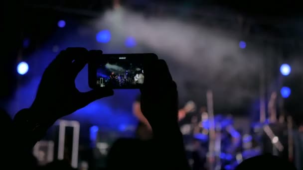 Manos irreconocibles silueta grabación de vídeo de concierto con smartphone — Vídeo de stock