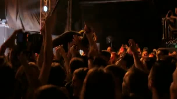 Folk som festar på en rockkonsert framför scenen. — Stockvideo