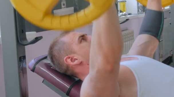 Αθλητική νεαρός άνδρας κάνει ασκήσεις με barbell στο γυμναστηριο, γυμναστήριο — Αρχείο Βίντεο