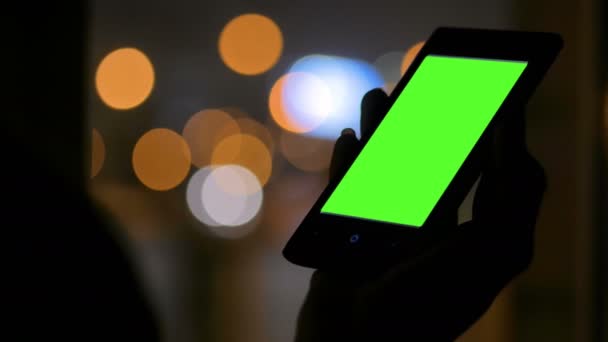 Vrouw op zoek naar smartphone met groen scherm — Stockvideo