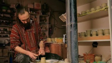 Çömlek atölyesinde özel bir aletle profesyonel çömlekçi şekillendirme kupası