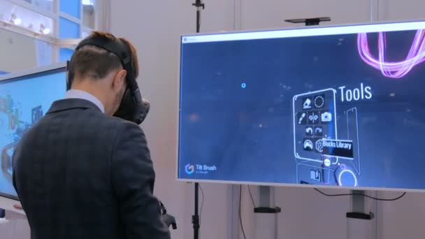 Ung man använder virtuell verklighet headset och ritning med särskild joystick — Stockvideo