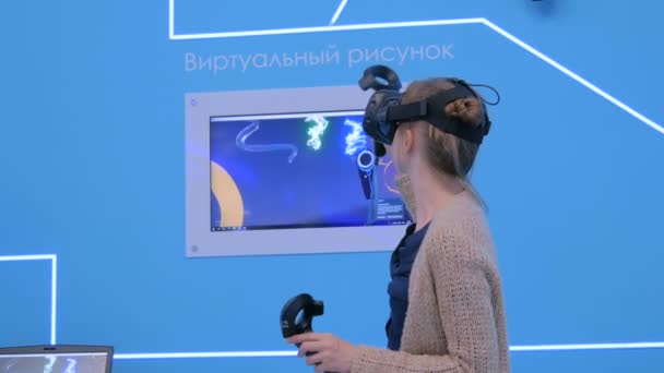 Jonge vrouw met behulp van virtual reality headset en tekenen met speciale joystick — Stockvideo