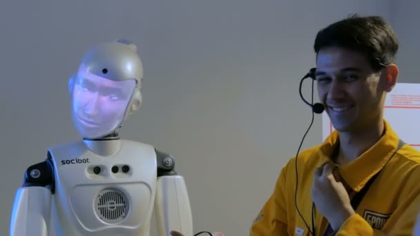 Divertente robot umanoide con display faccia parlando con guida, mostra di tecnologia — Video Stock