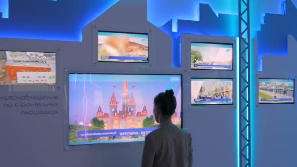Frau nutzt interaktives Touchscreen-Display bei moderner Technik-Ausstellung — Stockvideo