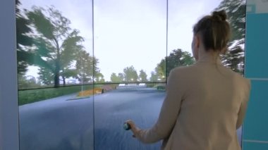 Etkileşimli bisiklet simülatörü kullanan genç bir kadın