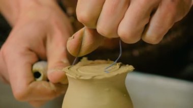 Çömlek atölyesinde özel bir aletle profesyonel çömlekçi şekillendirme kupası