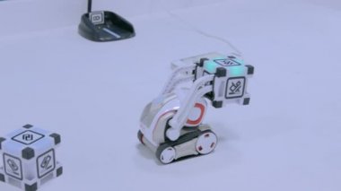 Komik gözlü küçük şirin robot küpleri taşır