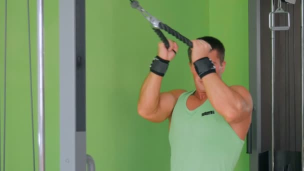 Athletischer junger Mann beim Training an Fitnessgeräten im Fitnessstudio — Stockvideo