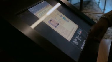 Modern tarih müzesinde etkileşimli dokunmatik ekran görüntüsü kullanan kadın