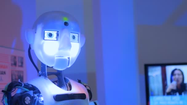 Смешной гуманоидный робот говорит и двигает руками на технологической выставке — стоковое видео