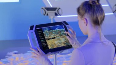 Modern teknoloji sergisinde etkileşimli dokunmatik ekran kullanan kadın