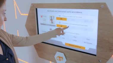 Modern teknoloji sergisinde etkileşimli dokunmatik ekran kullanan kadın