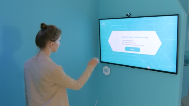 Женщина делает селфи перед интерактивным дисплеем — стоковое видео