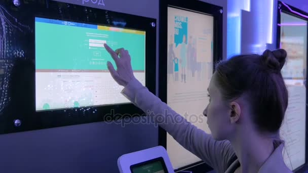 Vrouw met interactieve touchscreen display op moderne technologie tentoonstelling — Stockvideo