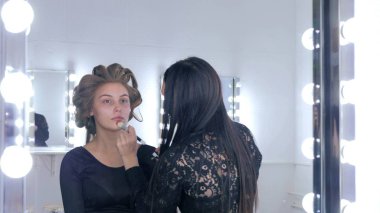 Sıvı ton temel uygulama kadının yüzünde makyaj sanatçısı