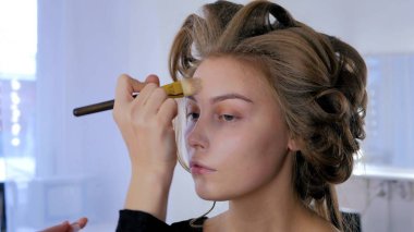 Sıvı ton temel uygulama kadının yüzünde makyaj sanatçısı