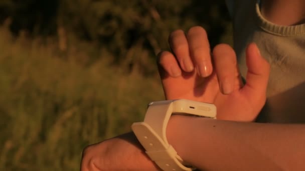 Kvinna med smart Watch-klocka i skogen vid solnedgången — Stockvideo