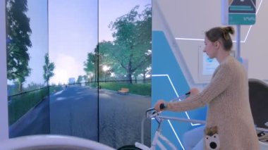 Etkileşimli bisiklet simülatörü kullanan genç bir kadın