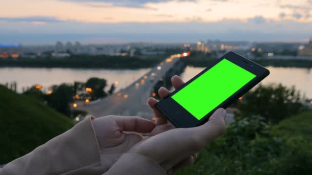 Woman looking at smartphone with green screen — Stock Video