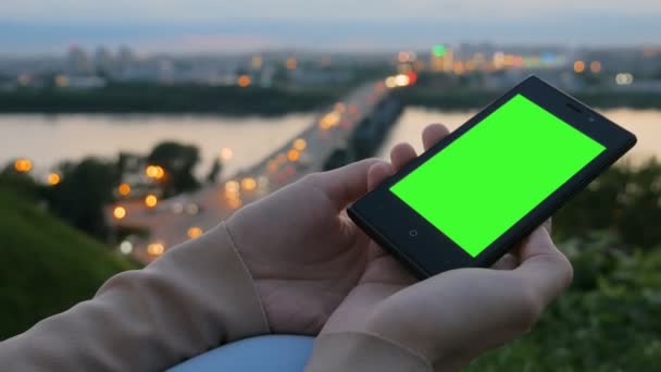 Woman looking at smartphone with green screen — Stock Video