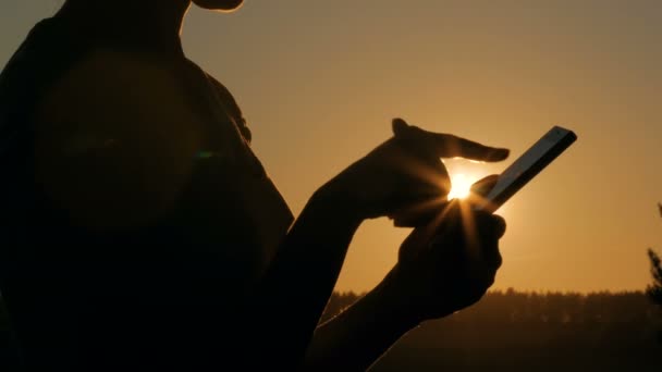 Mulher usando smartphone na floresta ao pôr do sol — Vídeo de Stock